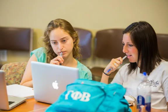 Two people working at a laptop